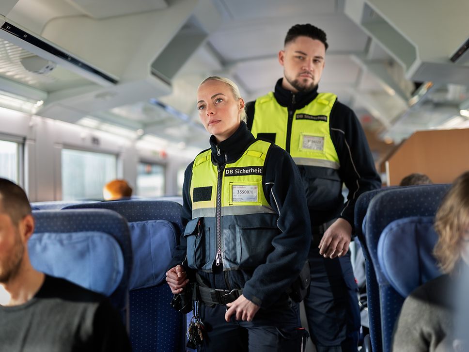Zwei Mitarbeitende der DB Sicherheit, die durch einen ICE gehen und prüfen, ob alles seine Ordnung hat